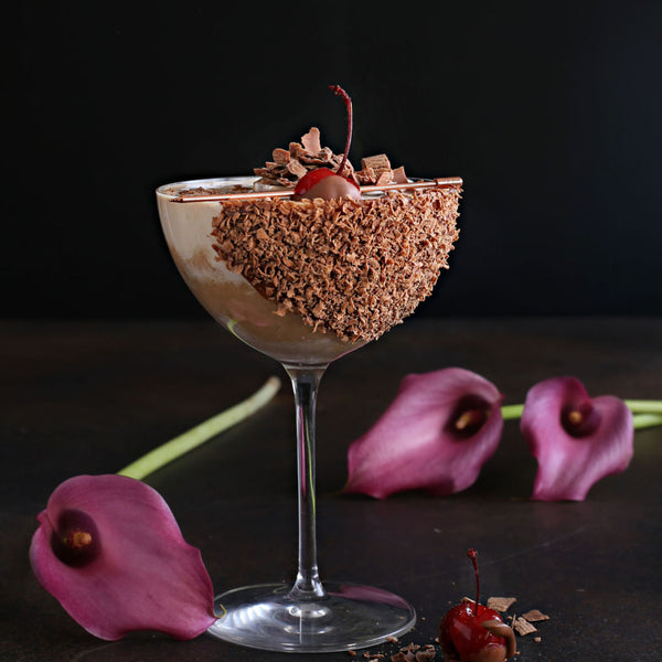 A Chocolate Covered Cherry Martini with vodka, crème de cacao, Rustic Oak Sour Cherry Mixer, served in a chocolate-dipped glass with cherry garnish.