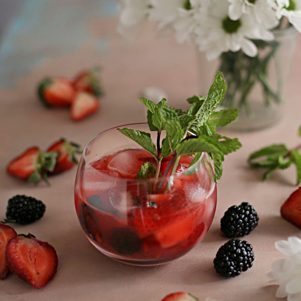 A Strawberry Blackberry Whiskey Smash with whiskey, lemon, Rustic Oak Blackberry Mixer, fresh strawberries, blackberries, and mint.