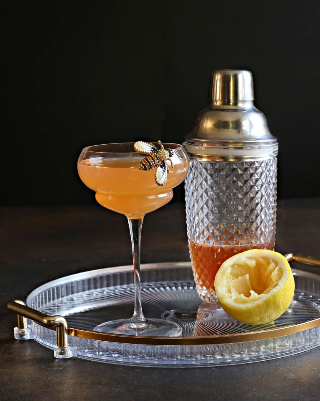 A zero-proof Bee's Knees with honey syrup, lemon juice, Rustic Oak Barrel Aged Mixer, and aromatic bitters, served in a chilled coupe glass.