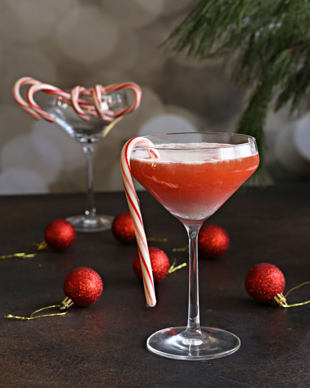 A festive Candy Cane Bourbon Sour with bourbon, candy cane syrup, meringue, and Rustic Oak Traditional Mixer, garnished with a candy cane.