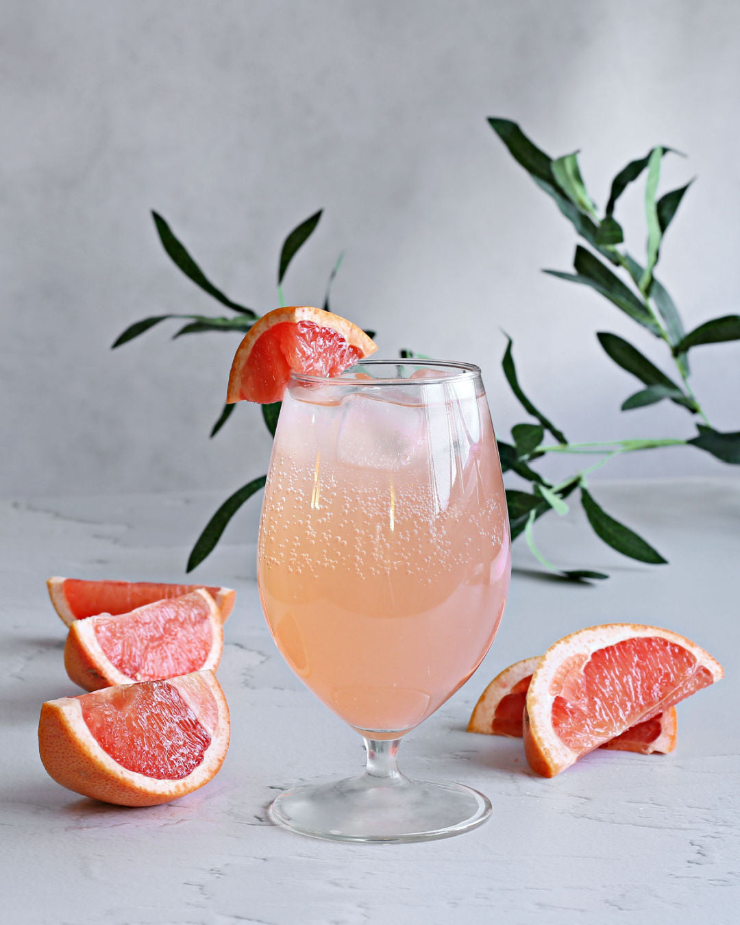 A bright zero-proof Grapefruit Spritz with Rustic Oak Traditional Mixer and club soda, garnished with a grapefruit slice.