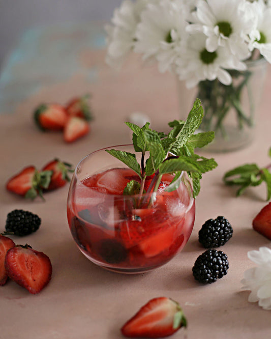 A Strawberry Blackberry Whiskey Smash with whiskey, lemon, Rustic Oak Blackberry Mixer, fresh strawberries, blackberries, and mint.
