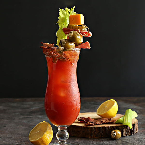 Loaded Bloody Mary garnished with bacon, blue cheese stuffed olives, salami, pickles, and cheddar cheese
