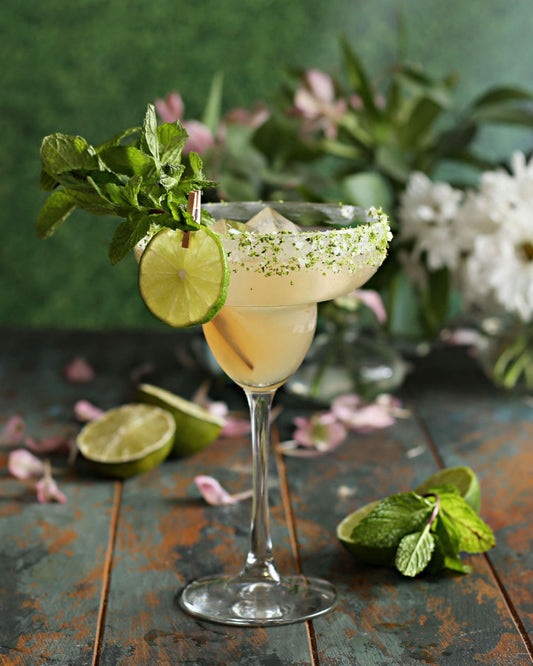 A Spring Garden Margarita with tequila, lime juice, Rustic Oak Orange Old Fashioned Mixer, and mint simple syrup, served with a lime-salt rim and fresh mint garnish.